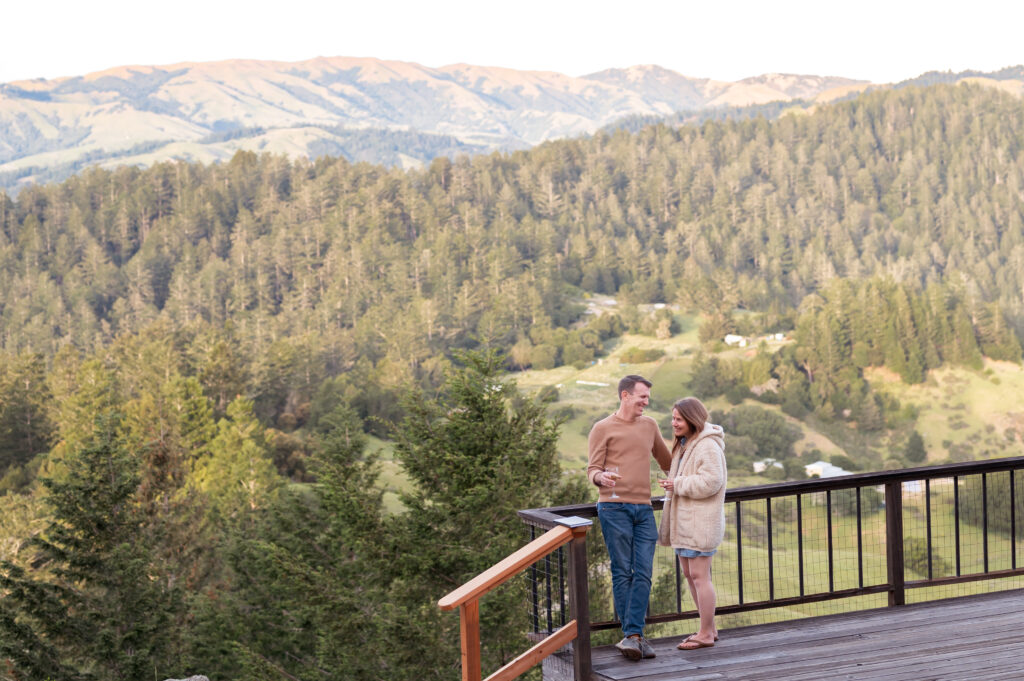 Couple sipping wine on deck with view of forests and the Nicasio hills.